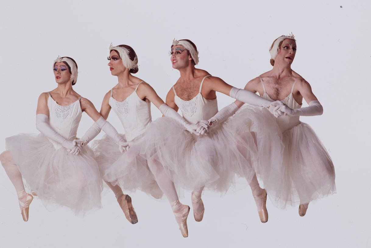 Four dancers wearing Swan Lake costumes interlace their hands as the Four Little Swans. One looks a different direction from the others. His face is terrified.